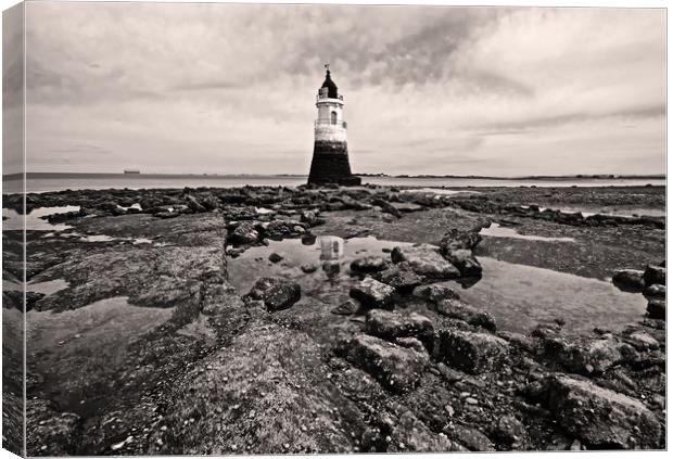 Lighthouse on a rocky shore Canvas Print by David McCulloch