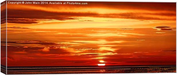 The Sun dips into the Sea Canvas Print by John Wain