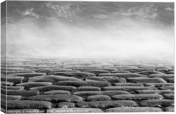 Wave splashes on cobbles monochrome Canvas Print by Graham Moore