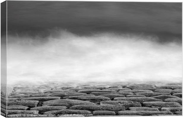 Waves on cobbles monochrome Canvas Print by Graham Moore