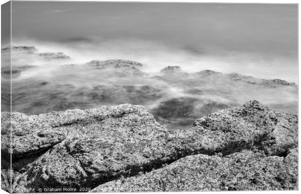 Waves on rocks monochrome Canvas Print by Graham Moore