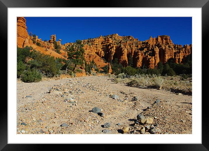 Dry river bed and orange rock towers Framed Mounted Print by Claudio Del Luongo