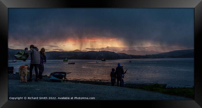 a shower of snow partially hides a sunset beyond loch Portree Framed Print by Richard Smith