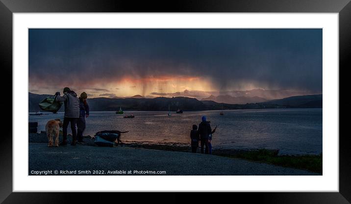 a shower of snow partially hides a sunset beyond loch Portree Framed Mounted Print by Richard Smith