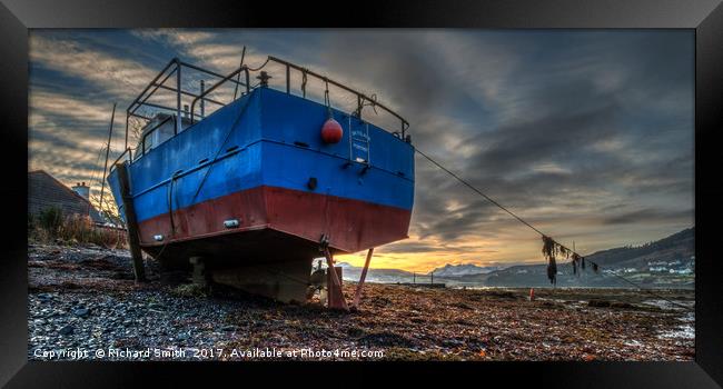 Sunrise colour beyond a beached vessel. Framed Print by Richard Smith