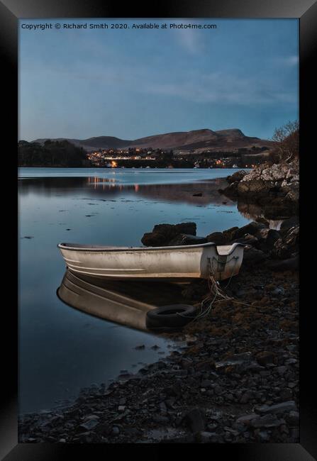 A dinghy moored on the shore of loch Portree reflected in the water  Framed Print by Richard Smith
