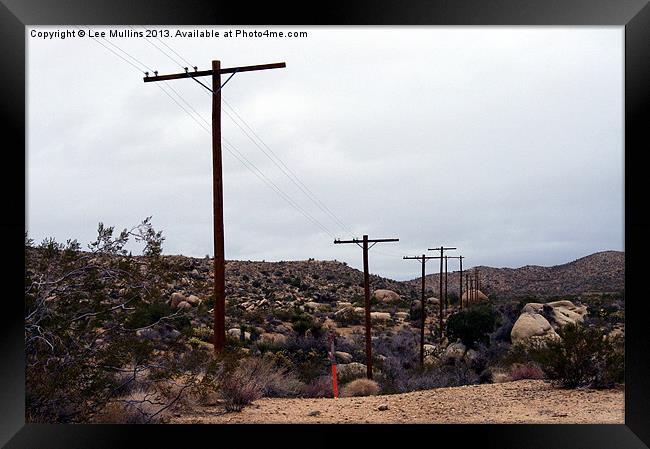 Telephone poles crossing the desert Framed Print by Lee Mullins