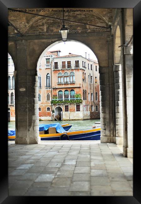 Venice Boat through Arches Framed Print by Jean Gill