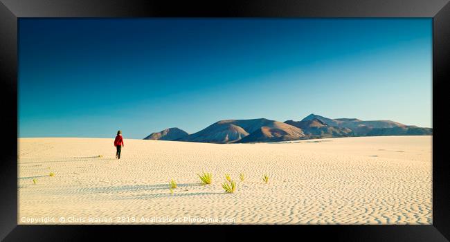 A lone figure walking on Sand dunes Corralejo  Framed Print by Chris Warren