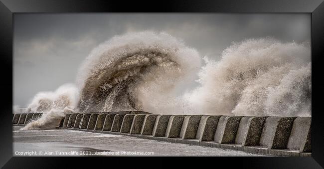 Large waves crashing over sea wall Framed Print by Alan Tunnicliffe