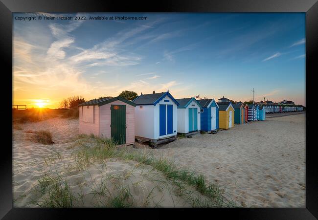 Sunset over a row of beach huts at Southwold  Framed Print by Helen Hotson