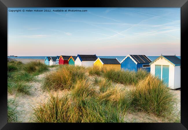Beach huts in the sand dunes at Southwold  Framed Print by Helen Hotson