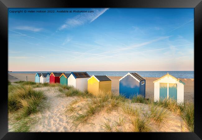Beach huts in sand dunes at Southwold  Framed Print by Helen Hotson