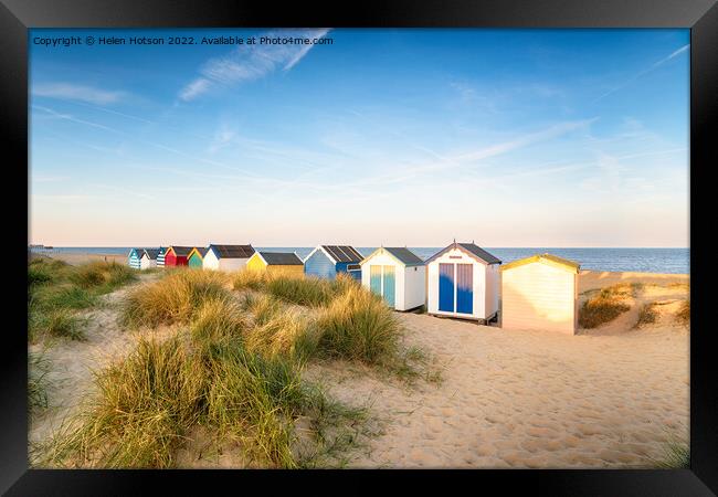 Colourfull beach huts in the sand dunes at Southwold Framed Print by Helen Hotson