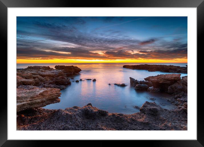 Beautiful sunrise over rocks at the beach at Torre de la Sal Framed Mounted Print by Helen Hotson
