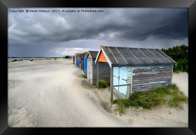 Beach Huts Under A Stormy Sky Framed Print by Helen Hotson