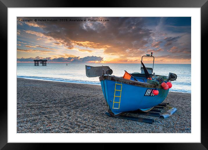 Dramatic sunrise sky over a fishing boat on the be Framed Mounted Print by Helen Hotson