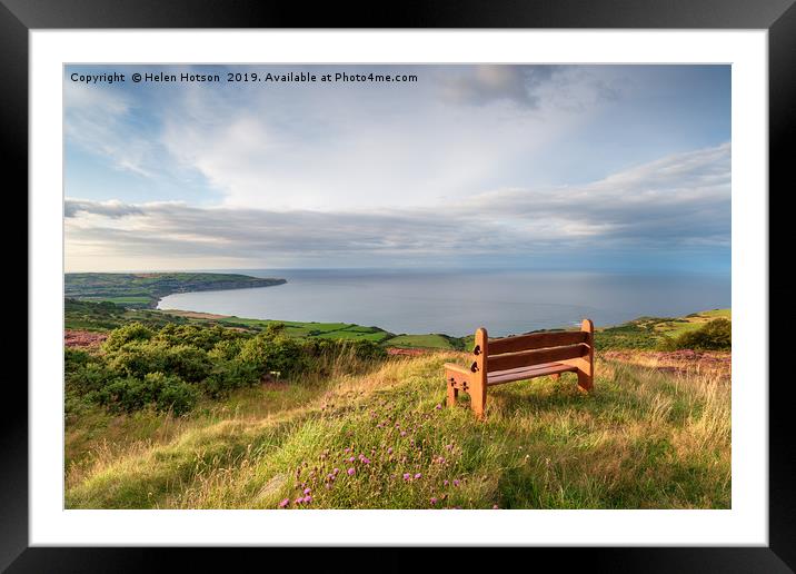 A wooden bench facing out to sea above Ravenscar o Framed Mounted Print by Helen Hotson