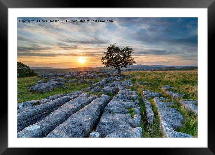 Sunset over a lonely windswept Hawthorn tree on a  Framed Mounted Print by Helen Hotson