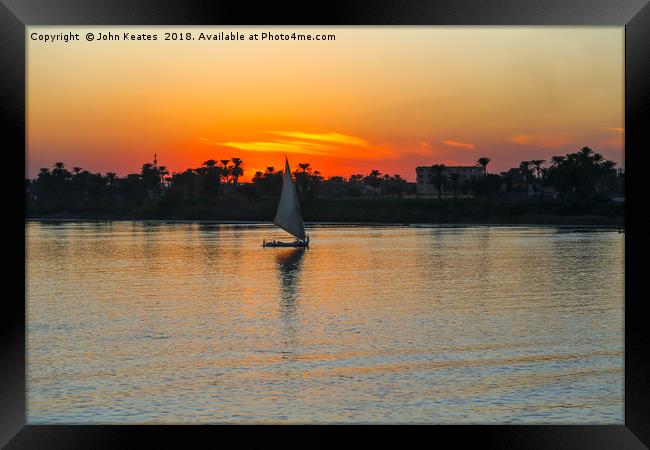 Sunset on the Nile River with Felucca boat sailing Framed Print by John Keates