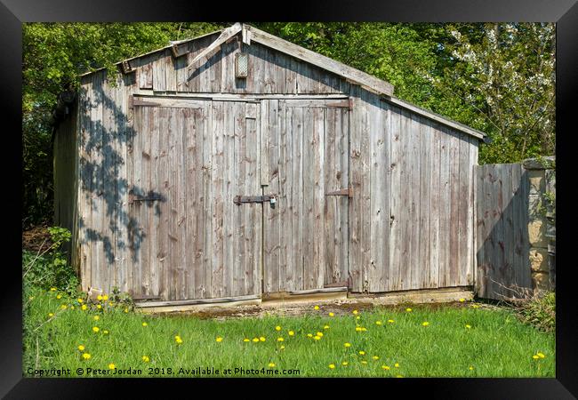 Weathered wooden out building garage in the Englis Framed Print by Peter Jordan