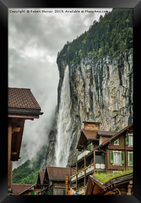 Lauterbrunnen town with waterfall backdrop Framed Print by Robert Murray