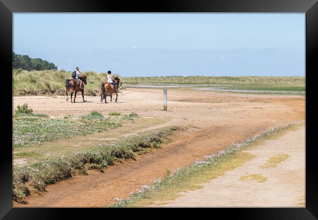 Couple riding horses on Holkham beach Framed Print by Jason Wells