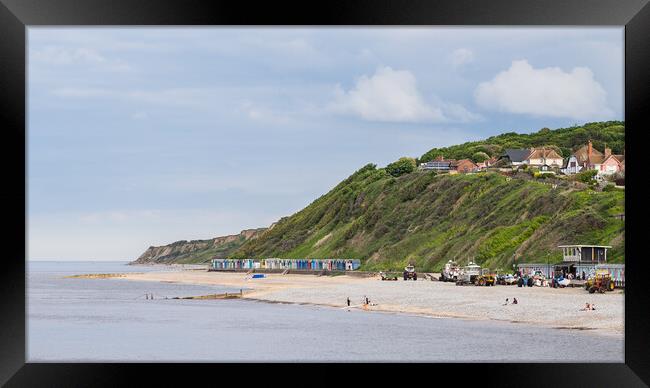 Beach huts sandwiched between the sea and cliffs at Cromer Framed Print by Jason Wells