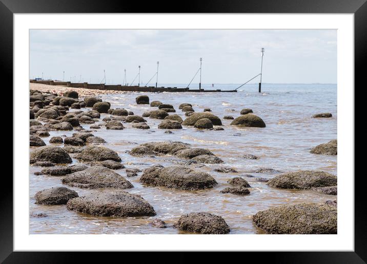 Waves lap up against the rock pools at Hunstanton beach Framed Mounted Print by Jason Wells