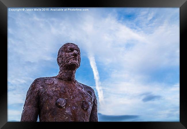 An Iron Man looks out to sea Framed Print by Jason Wells