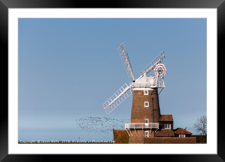 Flock of birds take to the skies behind Cley windm Framed Mounted Print by Jason Wells