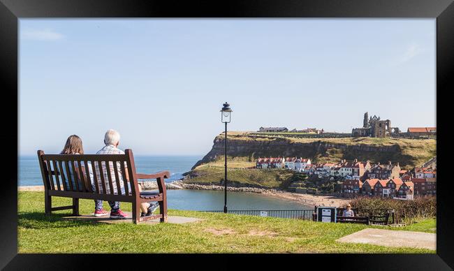 Couple on a bench overlooking Whitby harbour Framed Print by Jason Wells