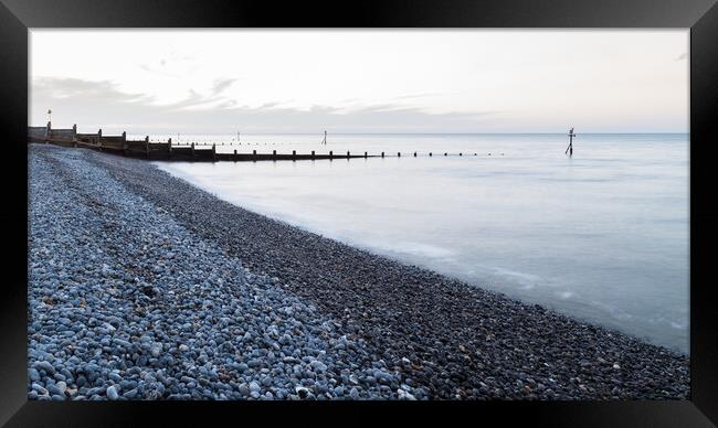 Groynes stretch out from the pebbly beach at Sheringham Framed Print by Jason Wells