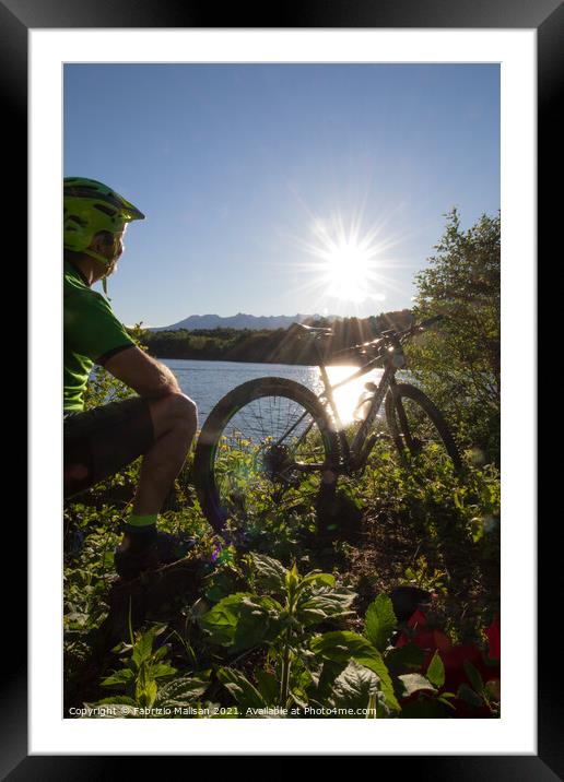 Mountain biking at sunset by the lake Framed Mounted Print by Fabrizio Malisan