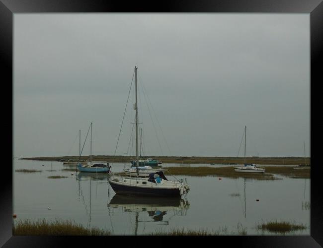 A Yacht reflecting in the water in Old Leigh in the Thames Estuary Framed Print by John Bridge