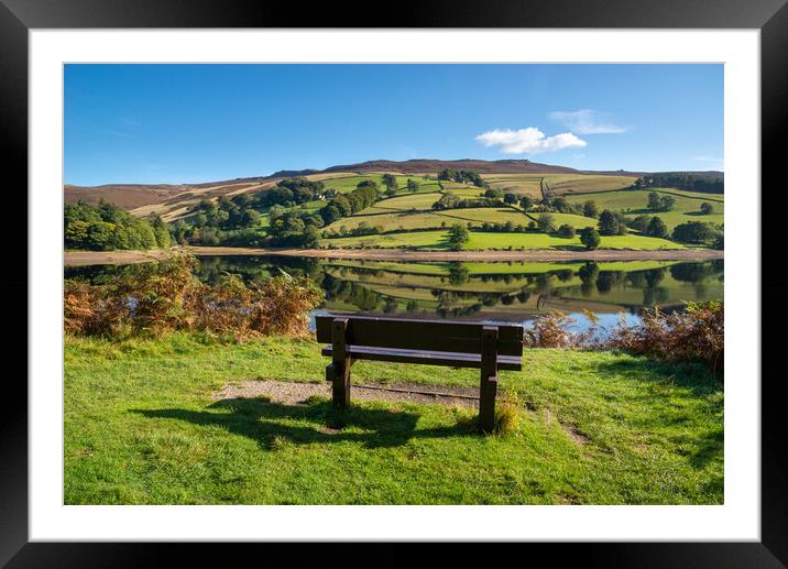 A wooden bench with views of Ladybower reservoir Framed Mounted Print by Andrew Kearton