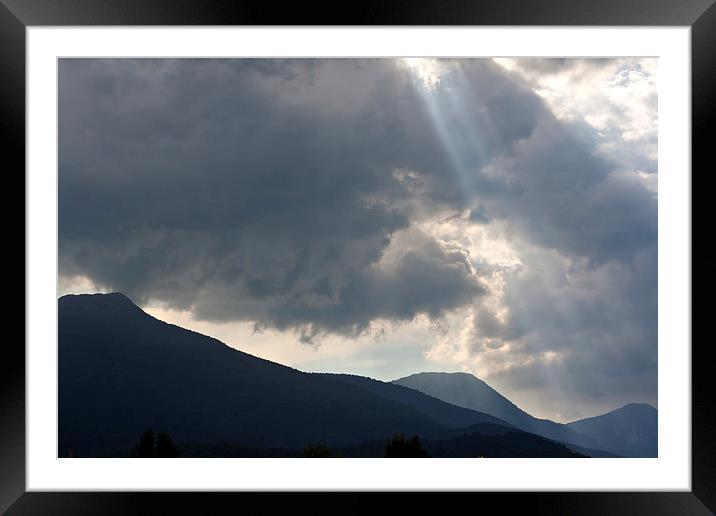 Sun rays through storm clouds Framed Mounted Print by ken biggs