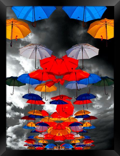 colorful umbrellas against a stormy sky Framed Print by ken biggs