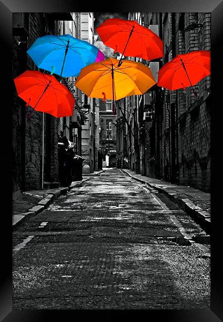  colorful umbrellas in a dark back street alley Framed Print by ken biggs