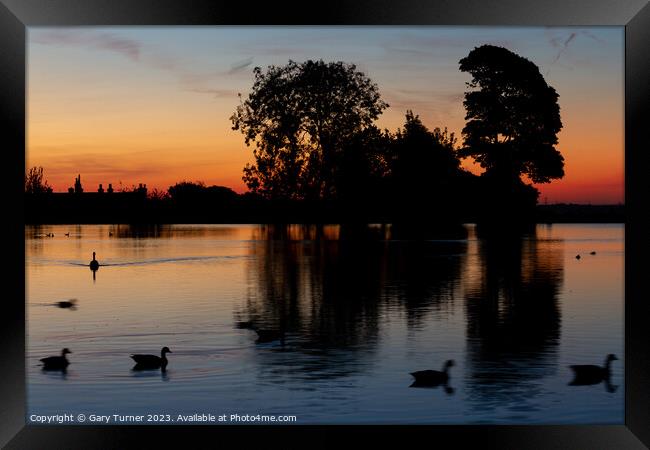 Sunrise reflected in the lake Framed Print by Gary Turner