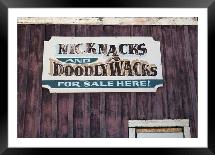 A faded tin sign on a wooden wall in Wyoming Framed Mounted Print by Adrian Beese