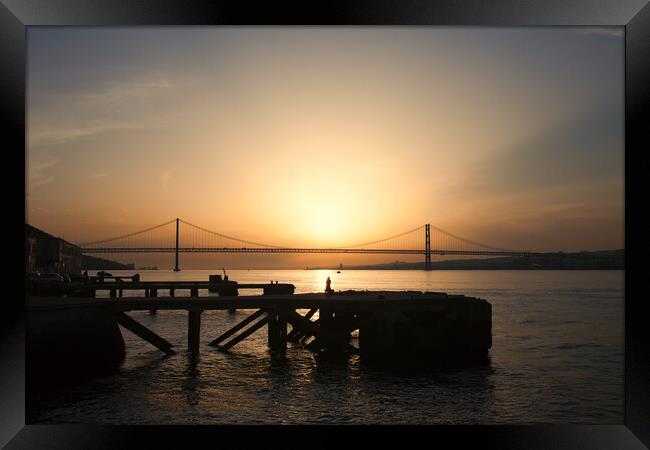Sunset at Almada Quay and 25 de Abril Bridge in Lisbon Framed Print by Artur Bogacki