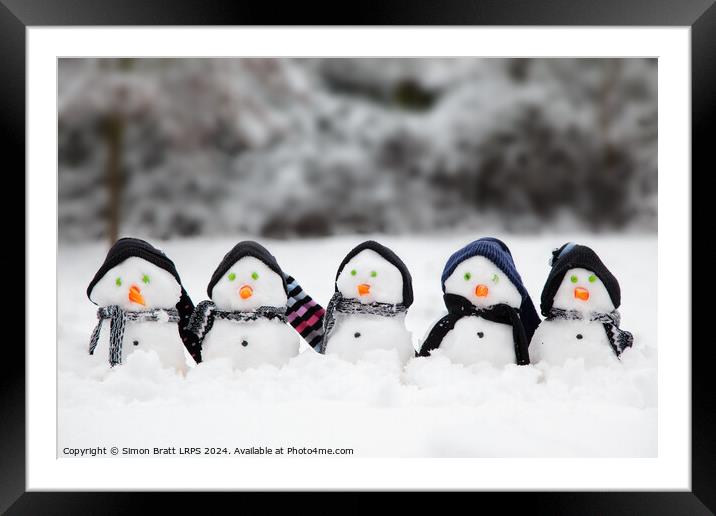 Cute little snowmen dressed in hats and scarfs in snow Framed Mounted Print by Simon Bratt LRPS