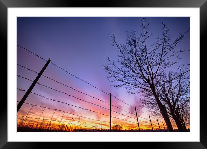 Fiery sunset viewed through barbed fence Framed Mounted Print by Simon Bratt LRPS