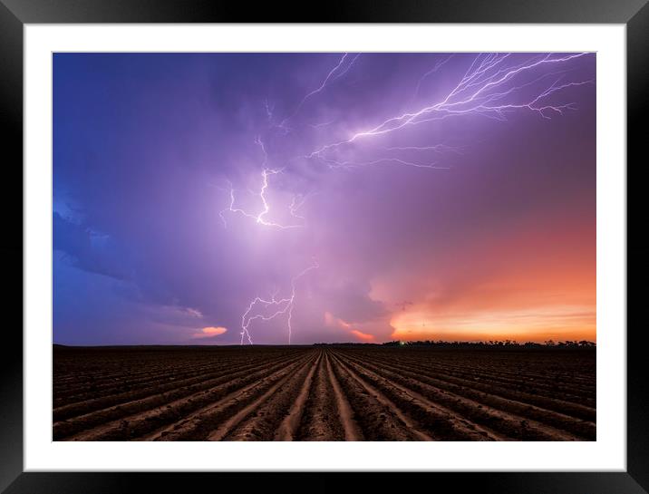 Lightning crawler over a ploughed field at sunset Framed Mounted Print by John Finney