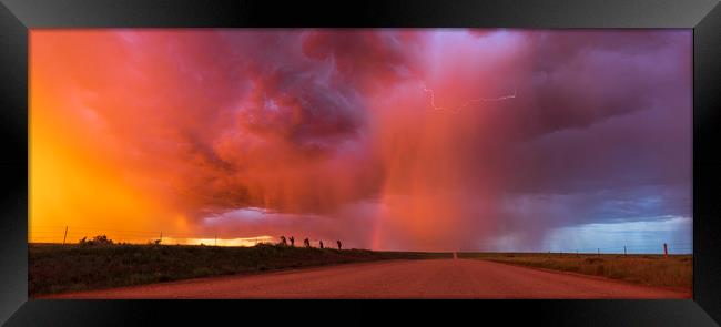 Sunset thunderstorm with rainbow and lightning. Framed Print by John Finney