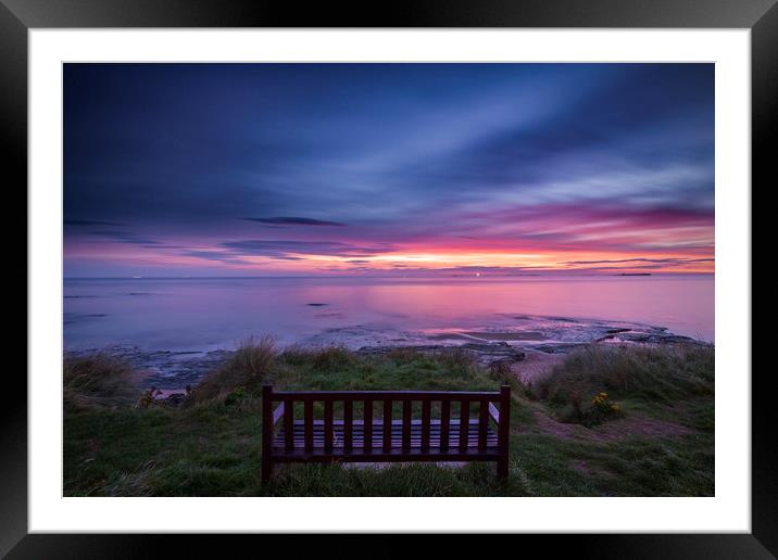 Bamburgh beach with a lone bench Framed Mounted Print by John Finney