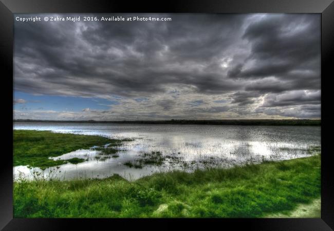 Dark Clouds reflecting in Marshes Framed Print by Zahra Majid