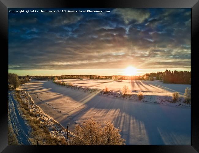 Sun Rising Over The Frozen River Framed Print by Jukka Heinovirta