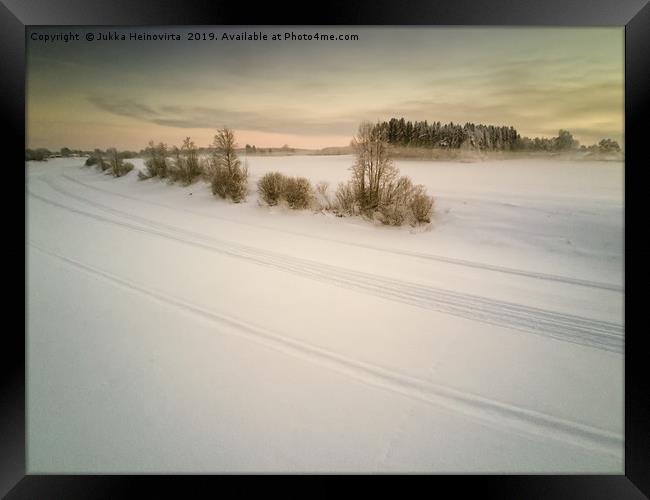 Snow Mobile Tracks On An Icy River Framed Print by Jukka Heinovirta